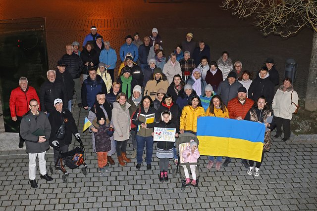 Eine Gruppe Menschen hält eine Ukraine-Flagge in der Hand